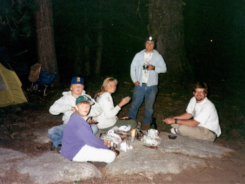 Group eating around the campfire at night