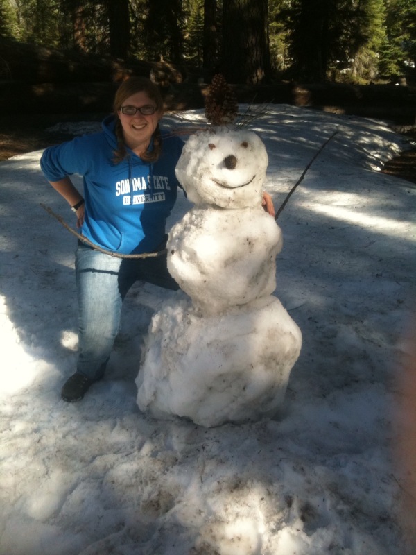 Woman posing with a snowman at the Kegger campsite, 2010