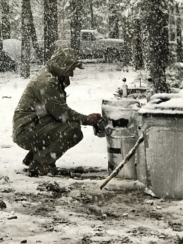 A Kegger participant tapping the keg in a snowstorm